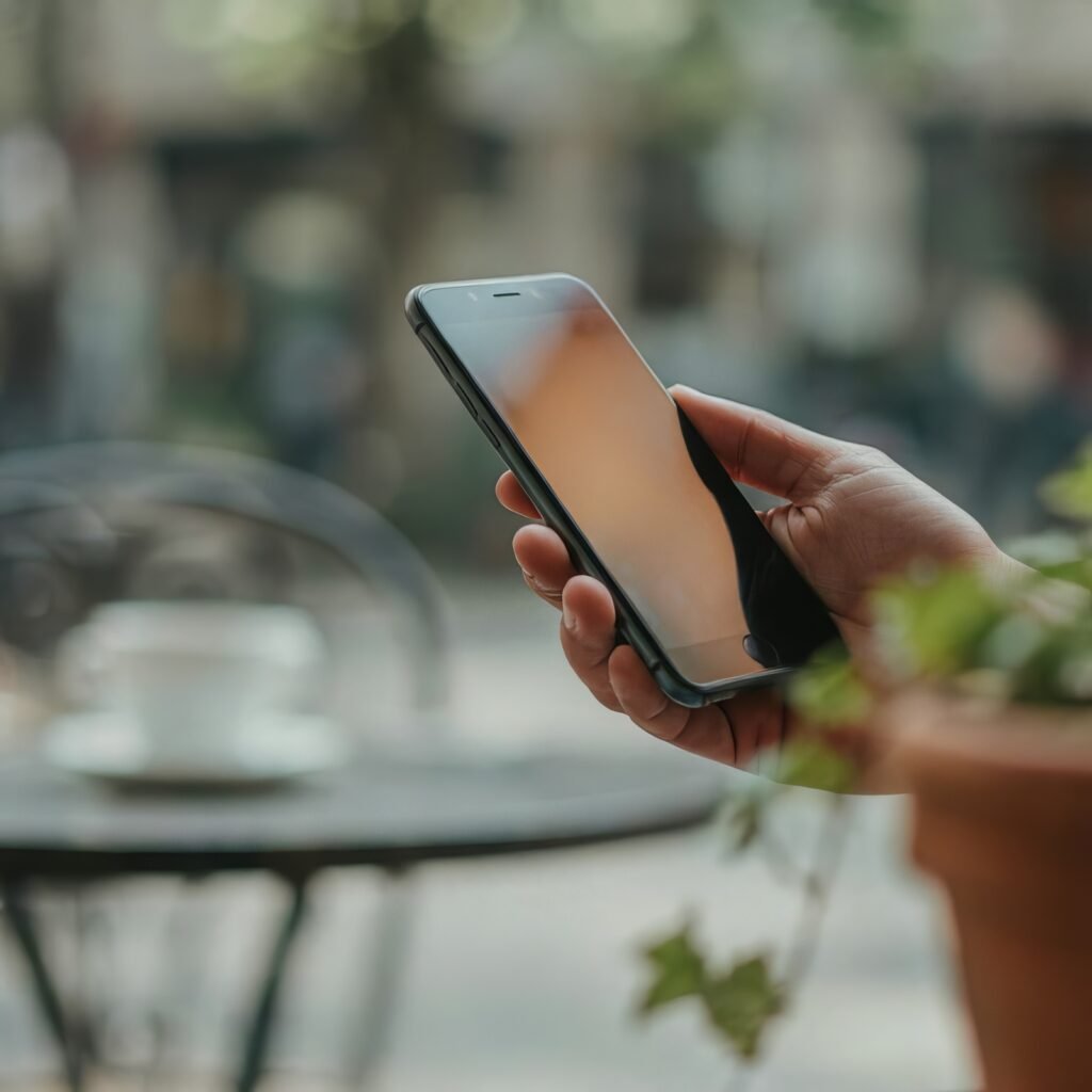 Close-up of a traveler holding a smartphone outdoors, checking their device before buying an eSIM data plan